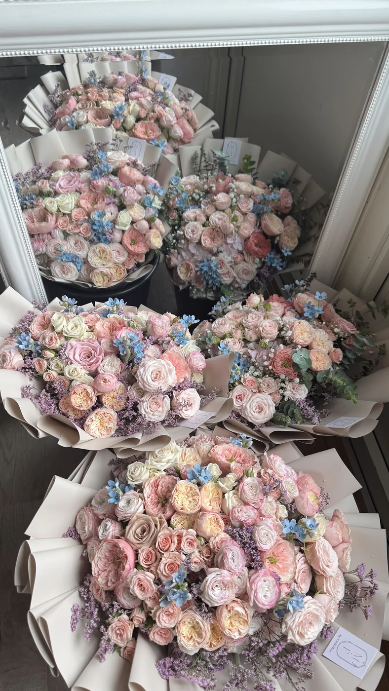 Pastellbuketter med rosor och ranunculus — Midosflowers, Malmö Flera stora pastellbuketter med rosor, ranunculus och blå småblommor uppställda i Midosflowers ateljé i Malmö