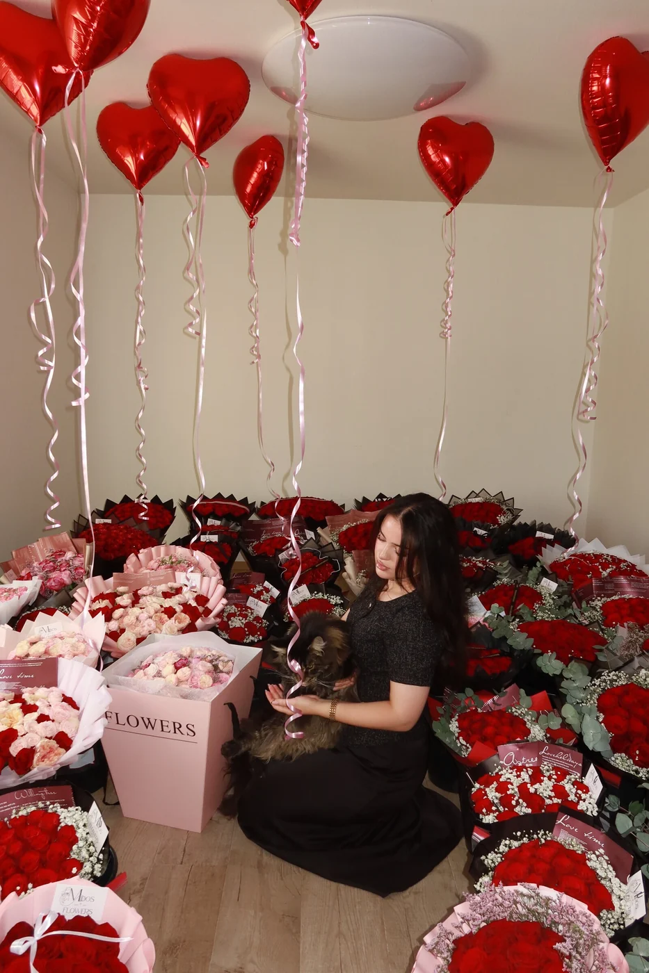 Alla hjärtans dag med röda rosor och hjärtballonger — Midosflowers Florist från Midosflowers omgiven av röda rosbuketter, blomsterboxar och hjärtballonger inför Alla hjärtans dag